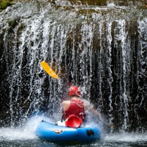 Osoba u kajaku vesla ispod slapa na Mrežnici