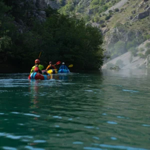 3 people in packrafts, approacing the big waterfall on Zrmanja river