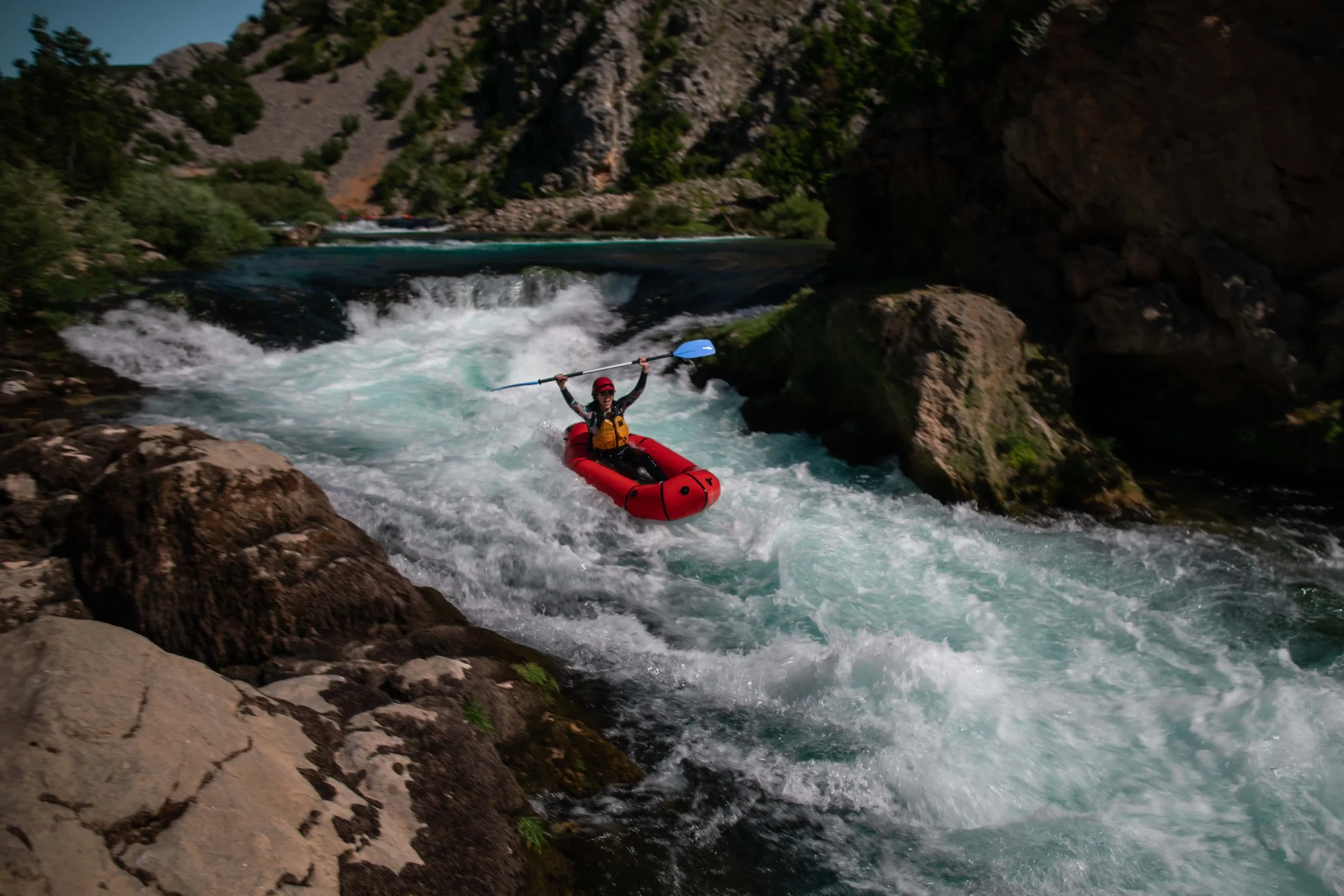 A person in a packraft, going down a rapid on Zrmanja River
