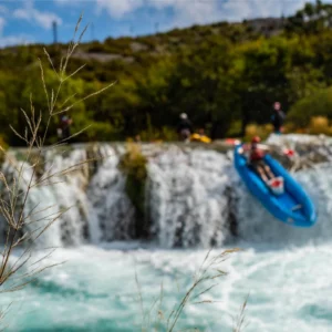 A person in a kayak going down a 3 meter waterfall on Zrmanja river