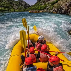 Group of people in a raft going down a rapid