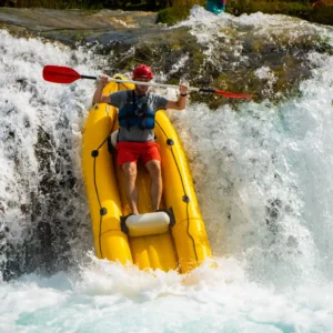 A person in a yellow kayak goind down a 3 m waterfall