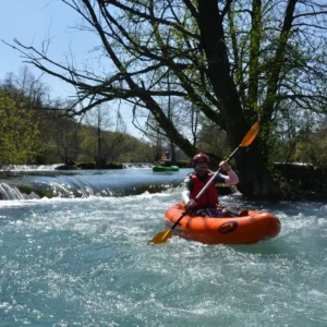 Person paddling in a packraft boat