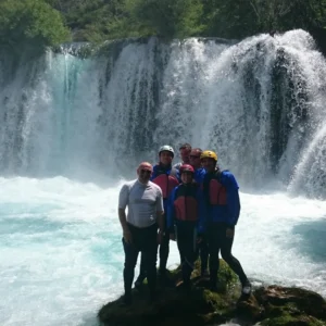 Group of people with the Krupa waterfall in the background