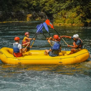Grupa ljudi slavi u raftu dignutih vesala