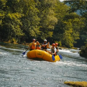 Grupa ljudi koji veslaju u raftu i idu niz rijeku Unu