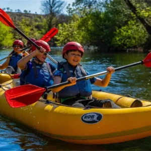 Two kids together in a kayak, paddling down Zrmanja River and having fun