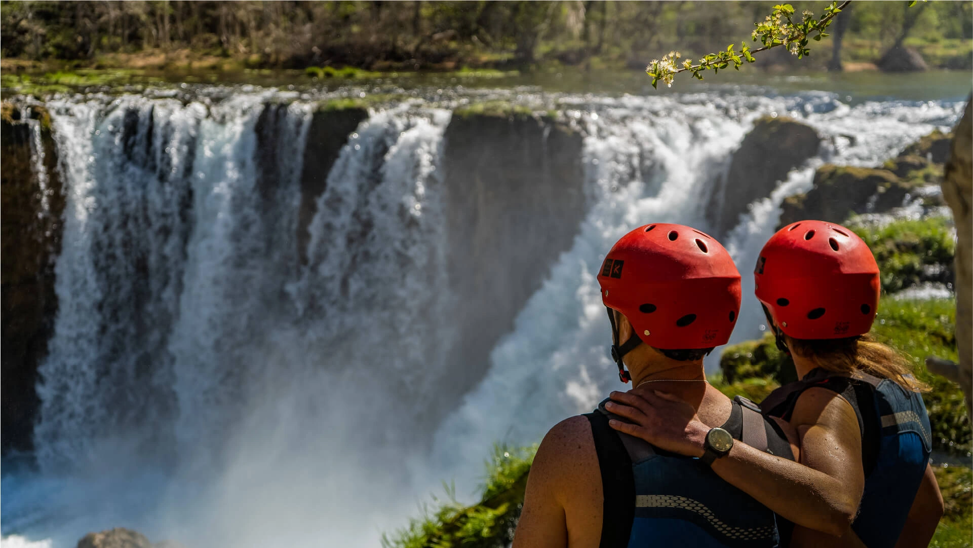 Picture of a couple hugging and looking at the big waterfall on Zrmanja River