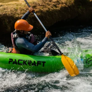 Person in a Packraft passing waterfall